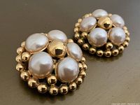 Front view of one earring showing central gold sphere, six faux pearls and beaded trim