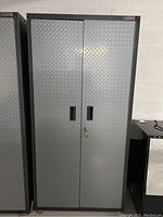 Front view of grey diamond plate tool cabinet with two doors
