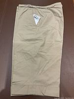 Front view of Hermes khaki shorts laid flat showing the belt loop and cuffed hem detail.