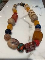 Full view of the natural stone beaded necklace showing different bead shapes and colors arranged along the strand.