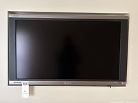 Front view of Sharp Aquos 36 inch flat screen TV on wall showing screen and frame.