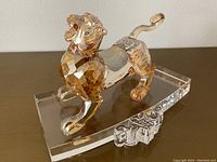 Front right three-quarter view of amber crystal tiger on clear base