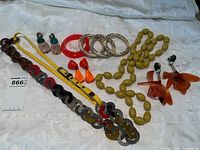 Wide overhead photo of all jewelry pieces showing variety including chunky linked necklace, olive bead necklace, bangles and earrings.