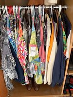 Closet overview showing assortment of Hawaiian and colorful shirts on hangers with Bally loafers on floor