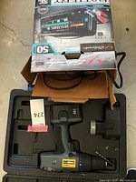 Nicole cordless drill and battery charger in black molded plastic carrying case with original box packaging.