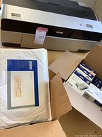 Epson Stylus Pro 3880 printer with some boxes of printing paper and supplies around it.