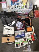 Overview of lot showing bag, ball boxes, towels, device and spikes