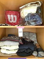 Shelf display showing stacked sweaters and tote bags