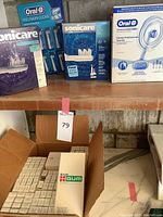 Top shelf showing two Philips Sonicare electric toothbrush kits, an Oral-B Precision Clean replacement heads pack, and an Oral-B Dental Professional Trial Kit