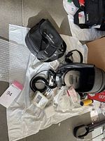 Overview of lot with Sony Discman in case, iPod with accessories, charger, headphones, and software CDs arranged on a cloth on floor.