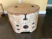 Front angle of the unique hollowed log side table showing the hinged top and handmade metal latches on front.