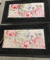 Two black door mats with pink floral and butterfly print in center, one larger and one smaller, placed side by side
