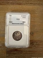 Photo of the 1938 Canadian 25 cents silver coin in protective grading case showing the obverse side with the year's date, denomination, and certification details.