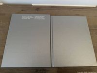 Two-part silver protective slipcover and hardcover album for the 1988 Canadian postage stamps souvenir collection, displayed on wooden surface.