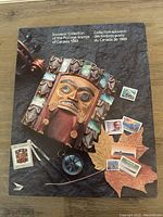 Front cover of the 1989 Souvenir Collection booklet displaying a carved wooden mask and samples of postage stamps along with a maple leaf graphic.