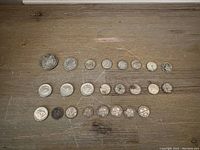Full display of all coins in the lot arranged by denomination and size on a wooden surface