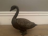 Full side view of the brass duck showcasing detailed feathers and overall shape