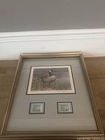 Framed Robert Bateman lithograph with two Canada goose stamps visible below the print.
