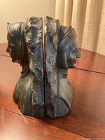 Side view of both bookends placed back to back showing the profile and detailed sculpting of the man and woman busts.