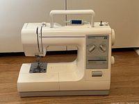 Front and side view of Kenmore 22 sewing machine showing overall condition and setup with thread spool.
