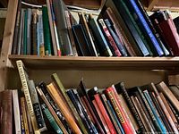 Shelf with assorted books including atlases and art books