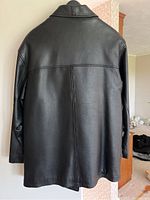 Full back view of the black leather jacket showing overall condition and cut.