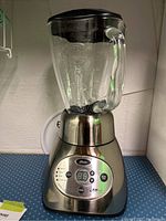 Full view of Oster blender showing the glass jar, stainless steel base, and control panel.