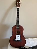 Full front view of vintage Hilo banjo-style ukulele with four nylon strings and dark wood finish.