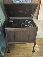 Front view of open Victrola cabinet showing turntable, tonearm and lower doors closed