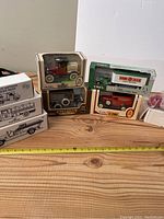 Photo showing 8 boxed die-cast Ertl vehicle banks including Amoco tanker, Shell tanker, fire truck, 1937 Ford model and other vintage-style cars and trucks.