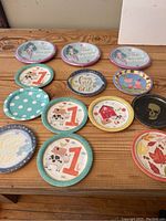 Photo showing assorted new paper plates with different designs arranged on wooden surface.