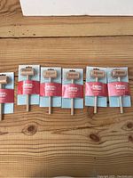 Six new wooden mallets branded KaBoom Chocolaka individually packaged, shown side by side on a wooden surface.