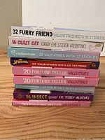 Stacked boxes of kids Valentines with themes and sticker counts visible on box spines