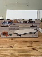 Box front showing Americana Classics 1500W Electric Griddle with product image and branding.