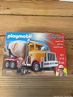 Front of the box showing the Playmobil cement truck with driver figure and accessories.