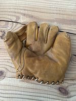 Front view of vintage Dubow genuine leather baseball glove showing finger sections and palm area with wear marks.
