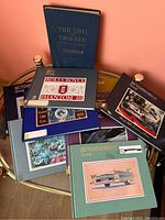 Photo showing multiple Automobile Quarterly hardcover books with various titles and covers including Rolls-Royce Phantom III and others, along with 'Triumph and Tragedy' book.