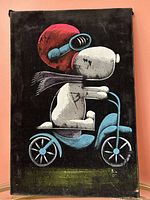 Full front view of vintage Snoopy velvet painting showing character on tricycle with bright colors on black velvet background.