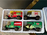 Four die cast metal classic style toy trucks in molded box, showing various colors and logos distinct to each truck.