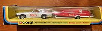 Side view of the boxed set showing white Jaguar model towing red race powerboat with Carlsberg logos.