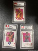 Three 1991 WWF playing cards featuring Hulk Hogan, Macho Man, and Miss Elizabeth all graded Gem Mint 10 in clear protective slabs.