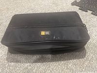 Closed black fabric carrying case with zippered closure for CDs