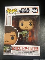 Front view of the Funko Pop figure in box showing The Mandalorian holding Grogu, item #461
