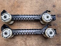 Full pair of adjustable hockey skate roller blades with visible wheels and sizing slots.