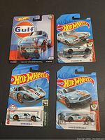 Four Hot Wheels Gulf livery cars new in package, showing front view of blister cards and clear plastic encasements containing diecast cars.