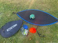 Overall soccer training set laid out on grass showing net, ball, cones, cords, pump and carrying bag