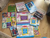 Overview photo of all items in the lot including craft books, coloring pads, sticker pad, coloring pencils, and Spiderman activity book.