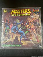 Front cover of the Masters of the Universe comic book "Caverns of Fear" sealed in plastic bag showing artwork and logos.