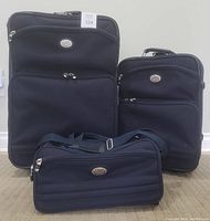 Front view of 3 blue Ciao Signature luggage pieces including large suitcase, carry-on, and personal bag.