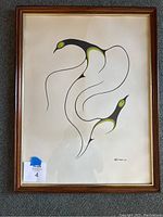 Framed print showing two stylized birds with black, green, and yellow colors on white background